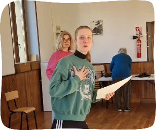 Personne habillée de vert avec une feuille à la main chantant