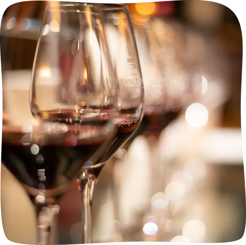 Verres de vin rouge en ligne vu de proche avec les derniers verres flous